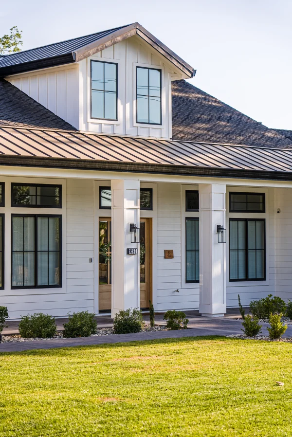White farmhouse with a dormer and front porch
