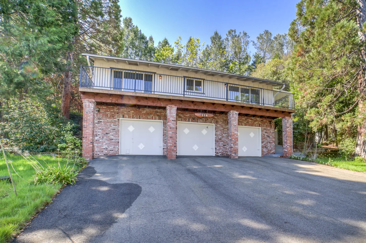 Two-story house with a brick base and three garage doors