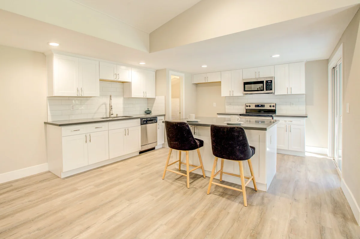 White kitchen with an island and black stools