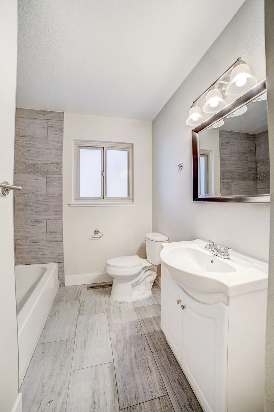 Bathroom with a white vanity and wood-look floor