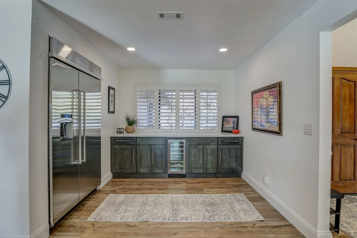 Kitchen wall with a built-in fridge and dark cabinets