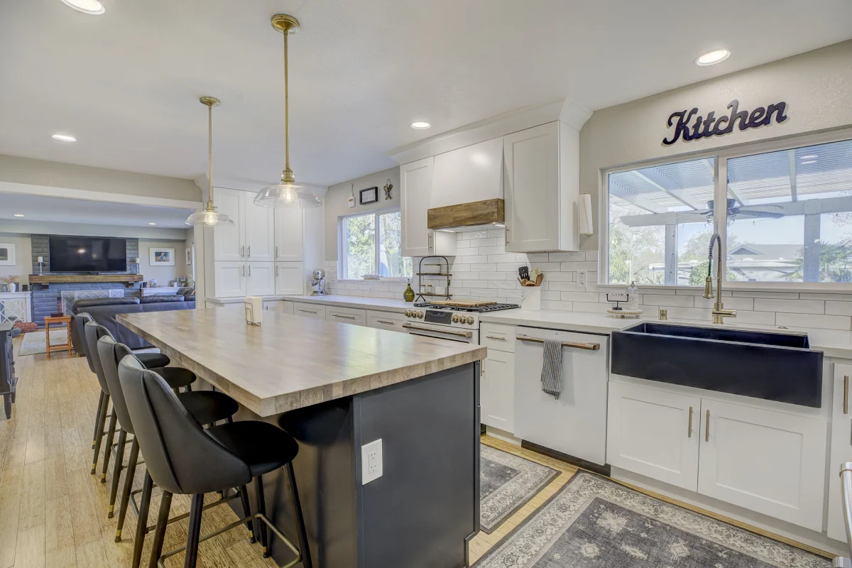 Kitchen with a long island, white cabinets and a black sink