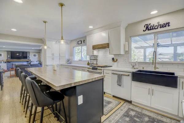Kitchen with a long island, white cabinets and a black sink