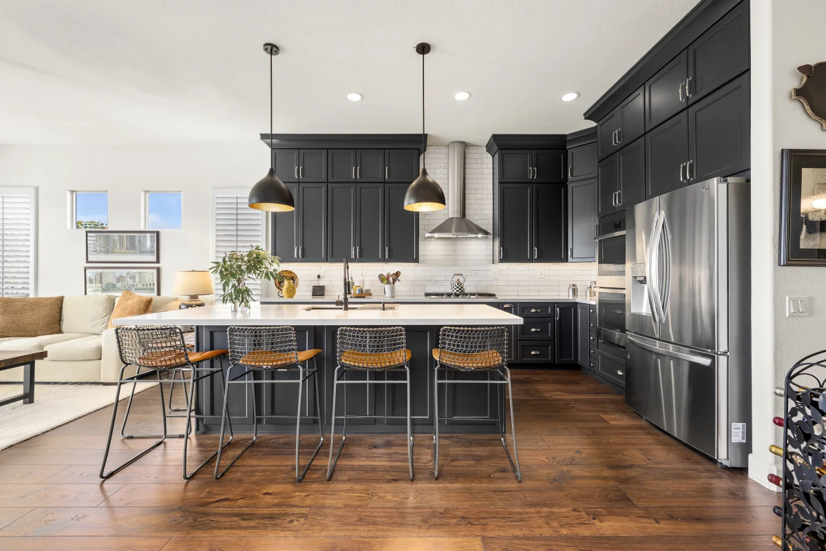 Kitchen with black cabinets and an island with stools