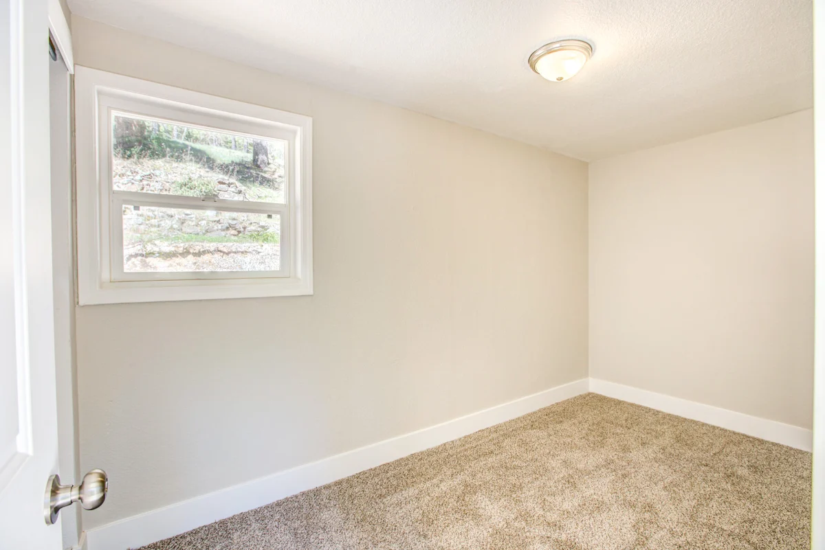 Bedroom with worn carpet before a remodel