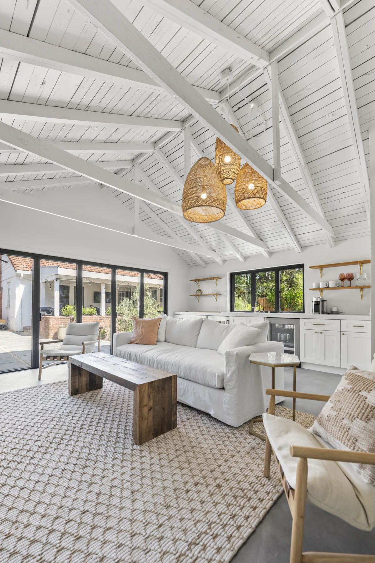 Converted garage living room with a vaulted white ceiling