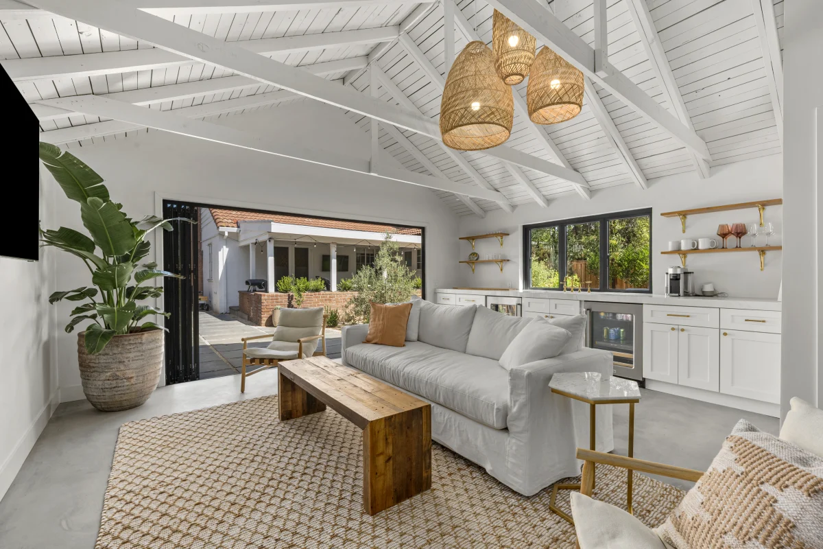 Garage converted into a bright living room with a vaulted white ceiling and a sectional sofa