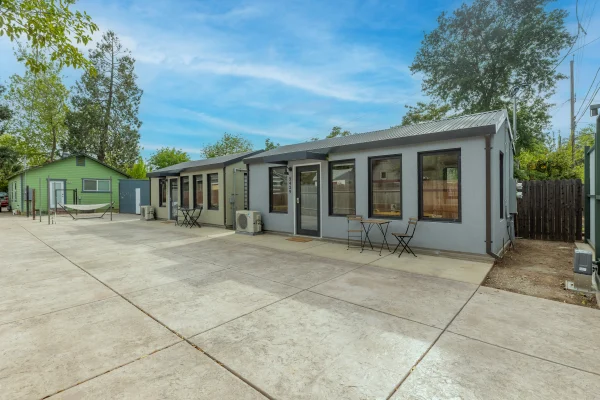 Two single-story backyard units beside a wide concrete yard