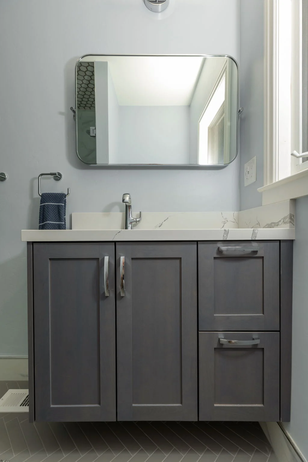 Bathroom with a gray vanity and a mirror