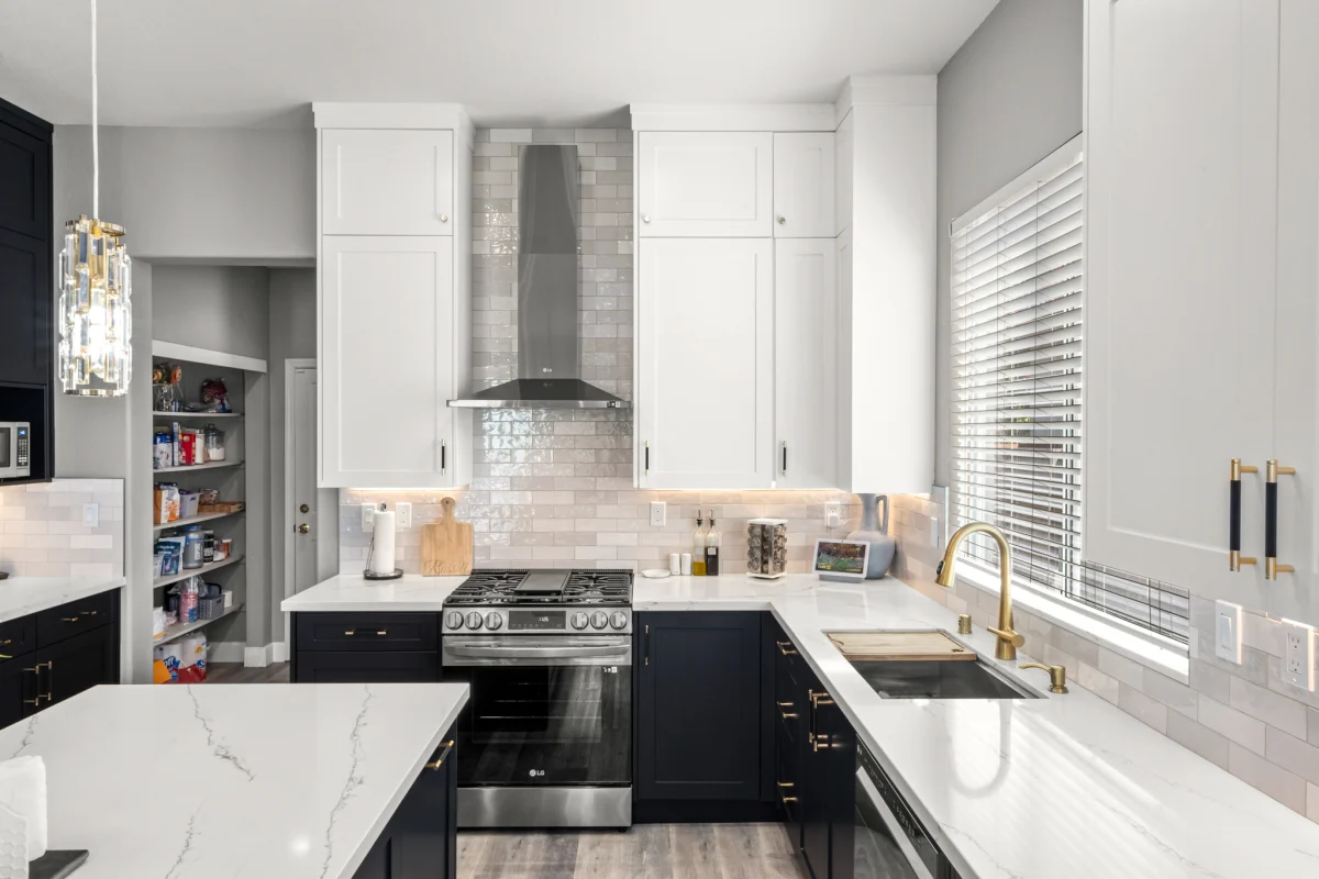 Kitchen with white upper and navy lower cabinets and a quartz counter