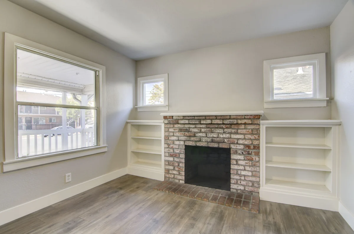 Room with a brick fireplace and built-in shelves