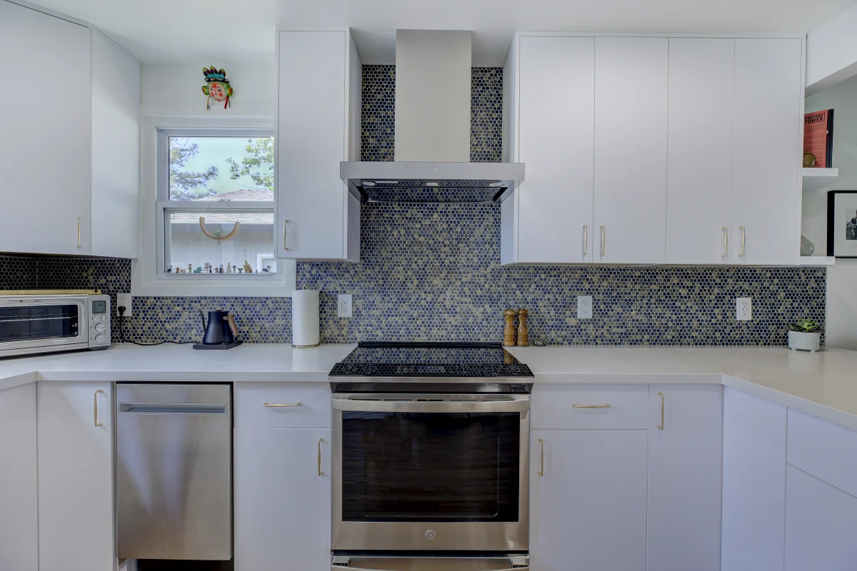 White kitchen with a dark mosaic backsplash