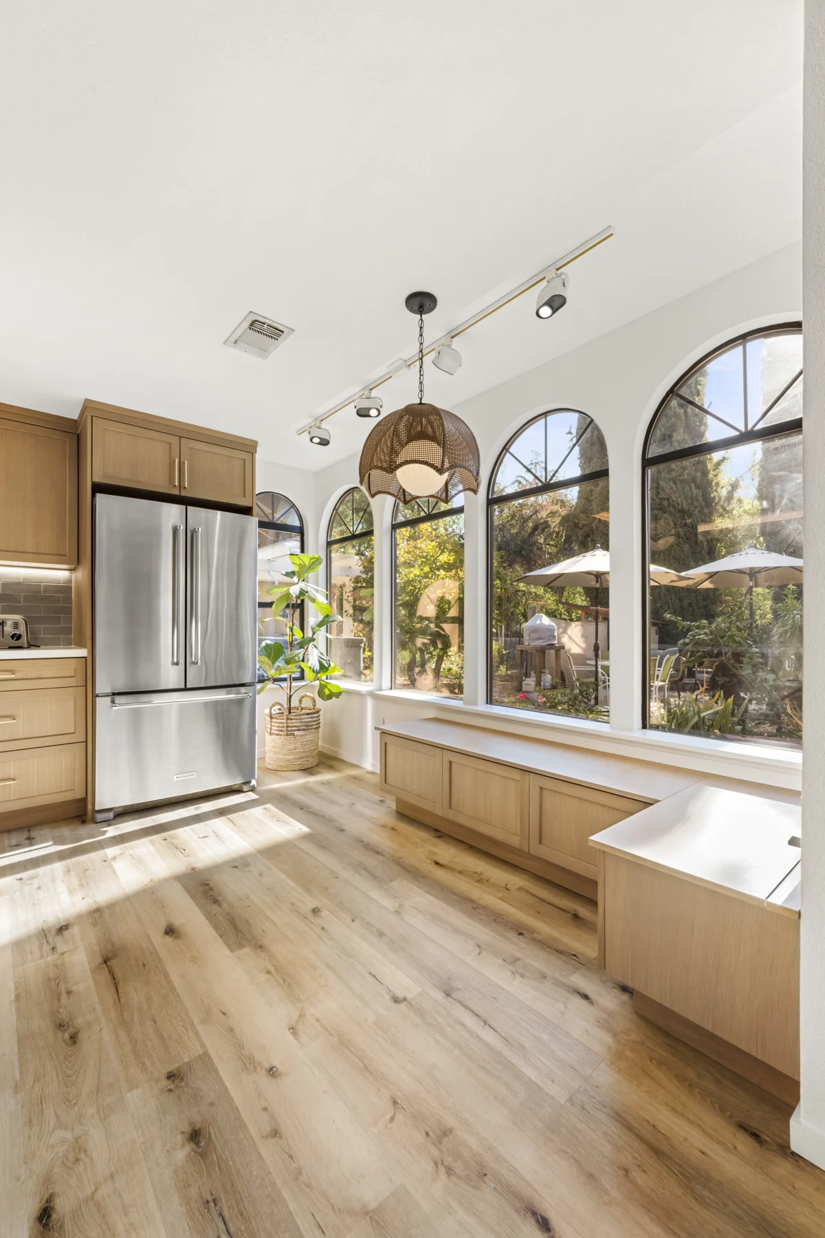 Kitchen with arched windows and light wood cabinets