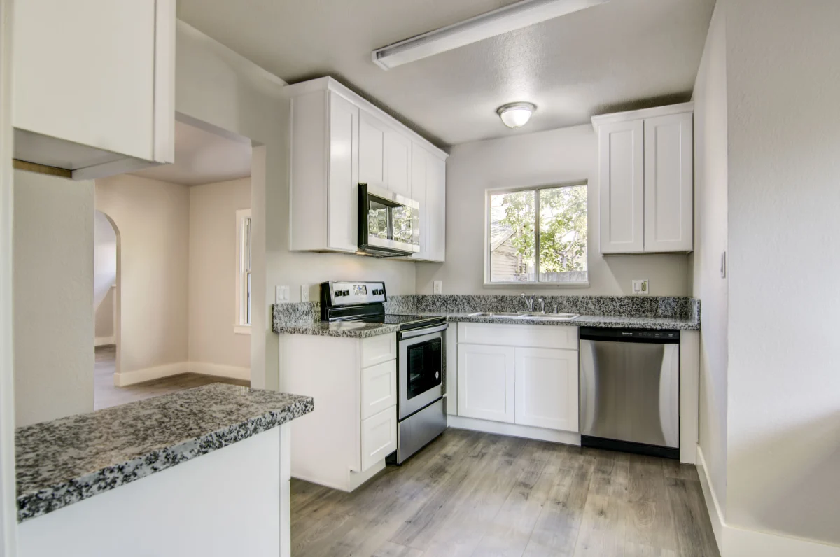 White kitchen with granite counters and stainless appliances