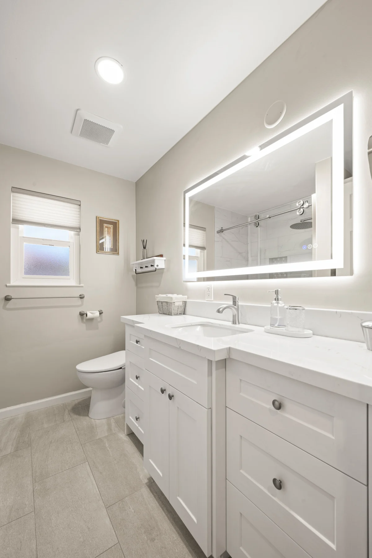 Bathroom with a white vanity and a lit mirror