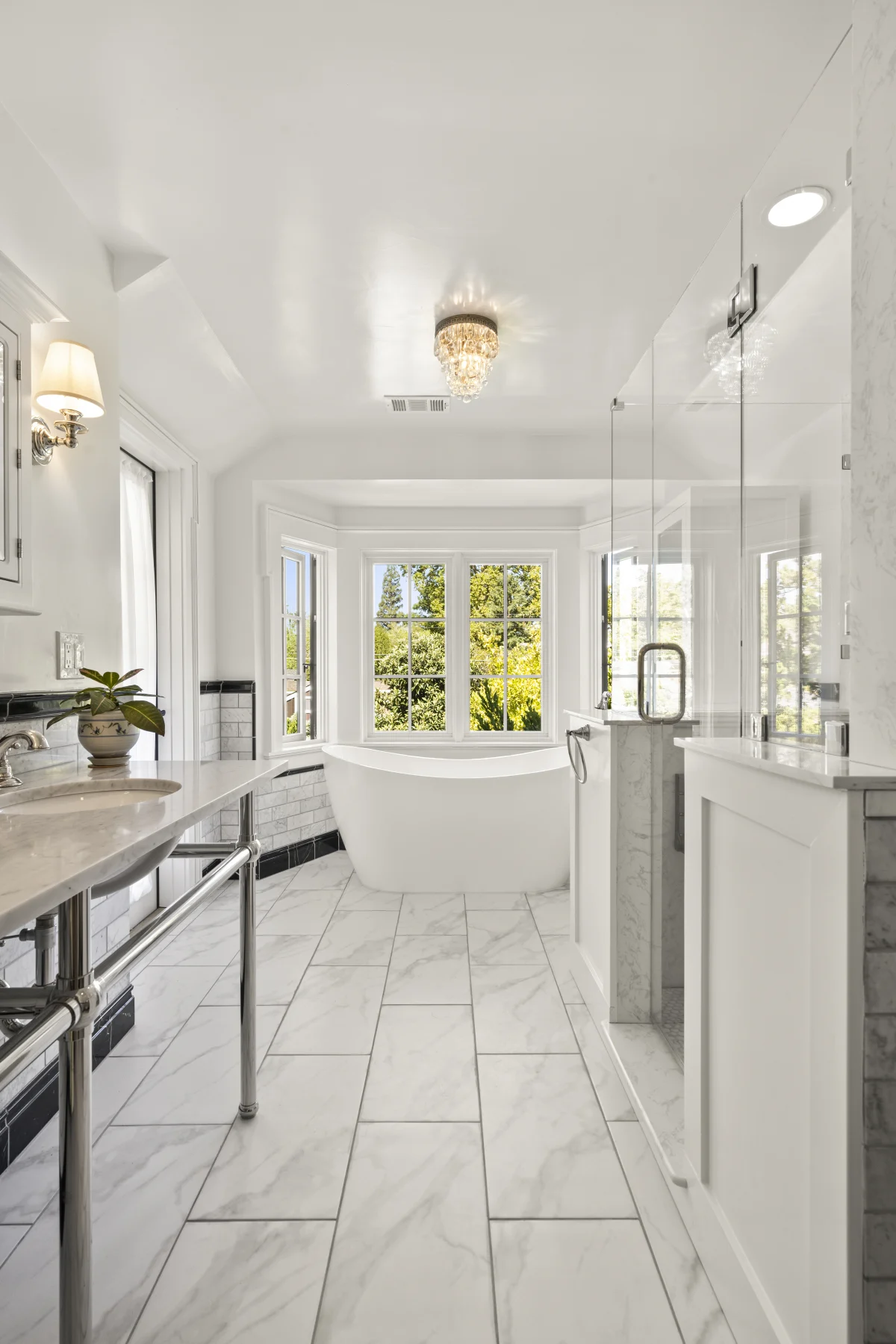 Long bathroom with a freestanding tub under windows