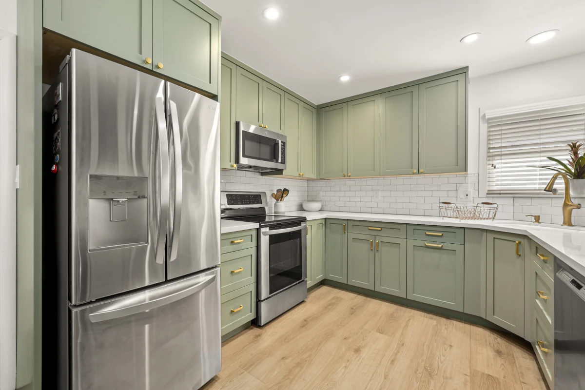 Kitchen with sage green cabinets and stainless appliances