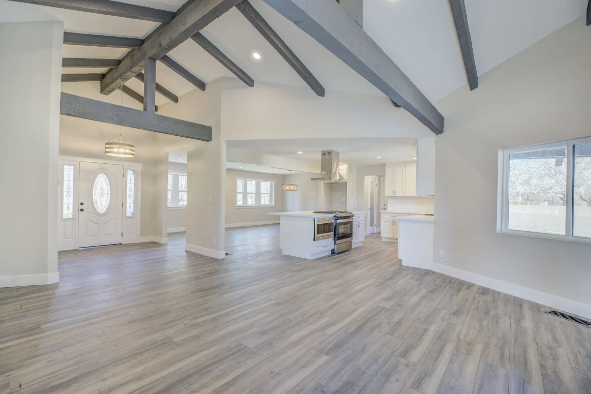 Open living area with a vaulted ceiling and gray beams