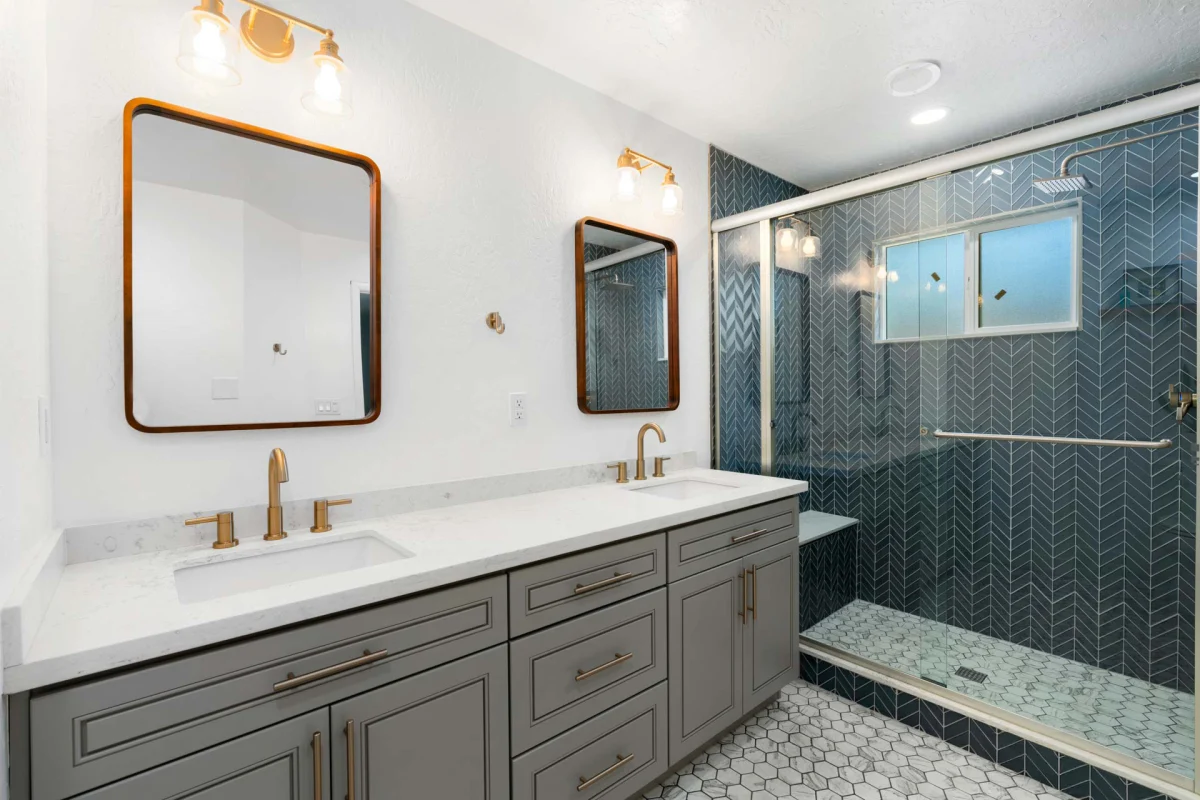 Bathroom with a gray vanity and a dark green tile shower