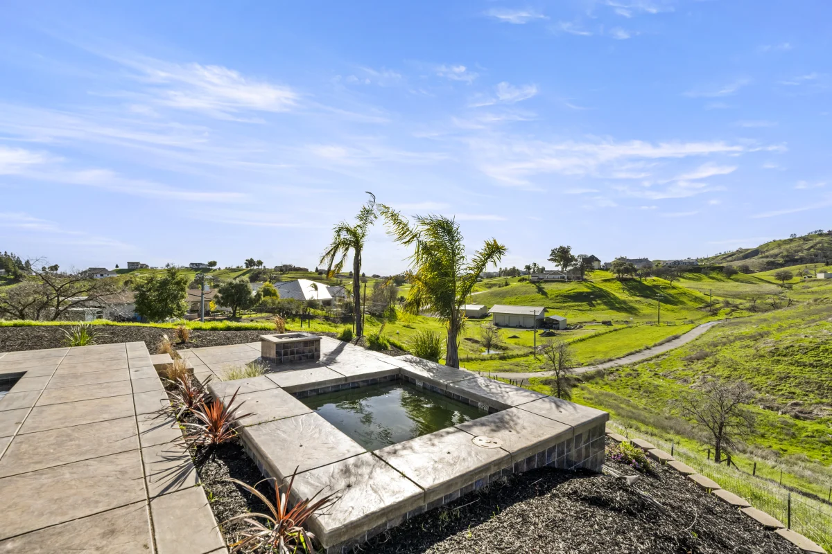 Raised spa with concrete coping above a textured pool deck