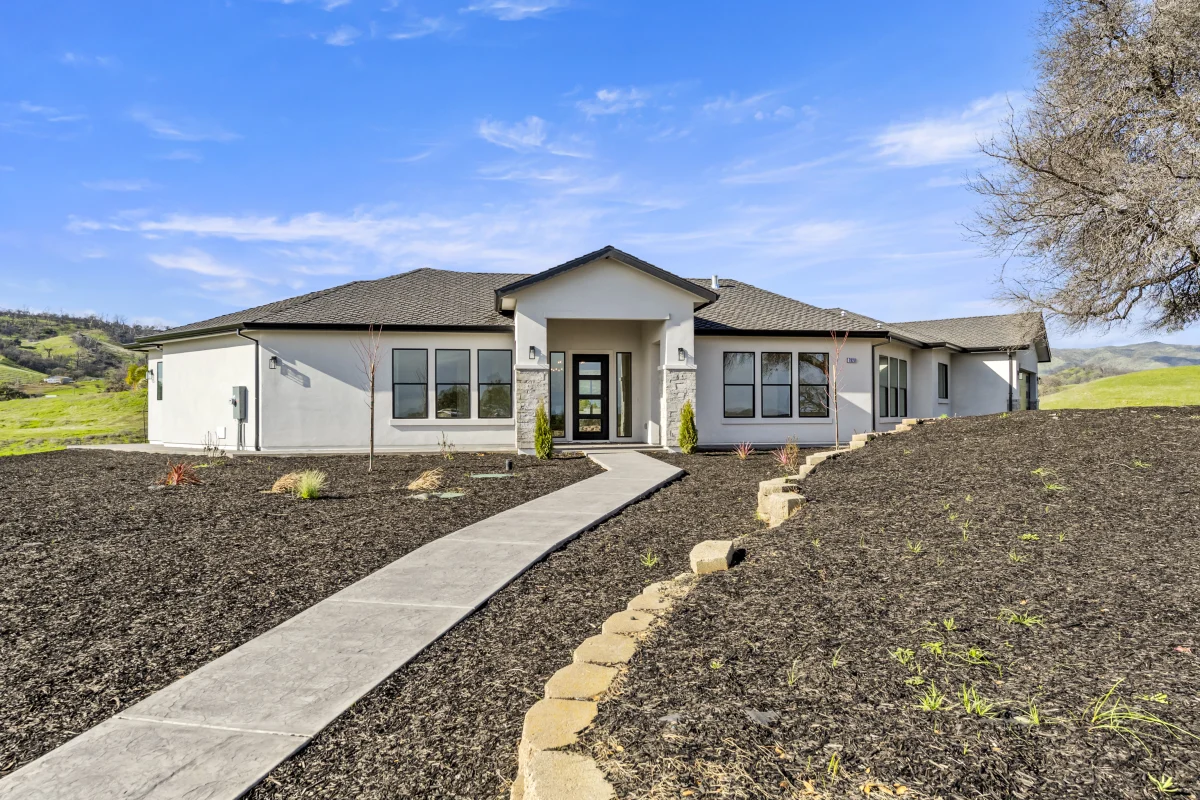 Concrete front walk leading to the entry of a Solid-built home