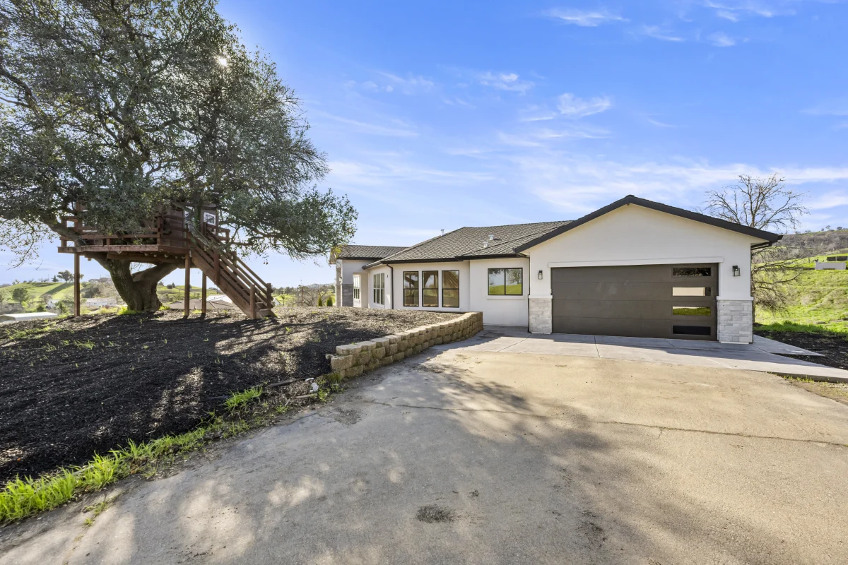 Concrete driveway apron leading to the garage, beside a block retaining wall