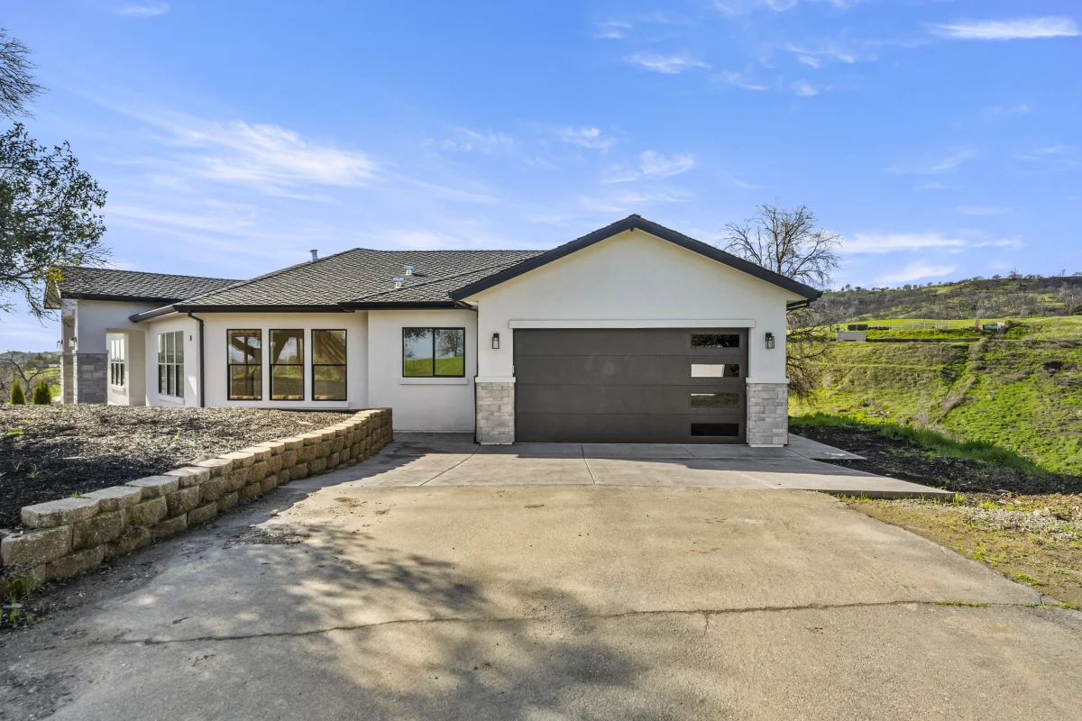 Broom-finish concrete driveway apron with control joints, leading to the garage of a Solid-built home