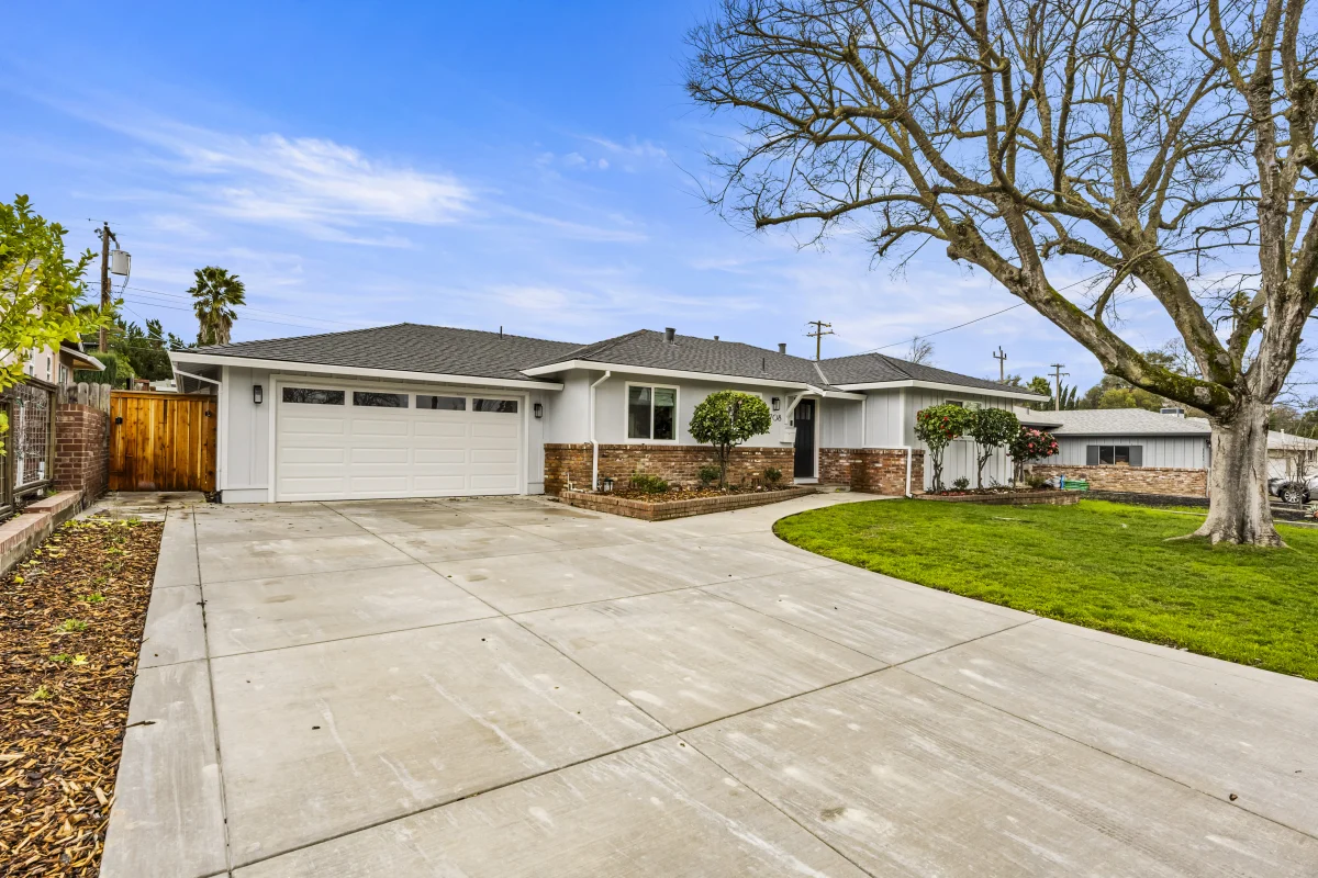 Single-story house with a long concrete driveway and a lawn