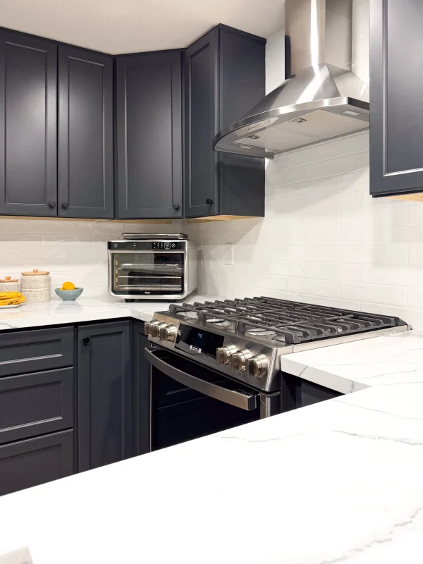 Kitchen with dark gray cabinets and a range hood