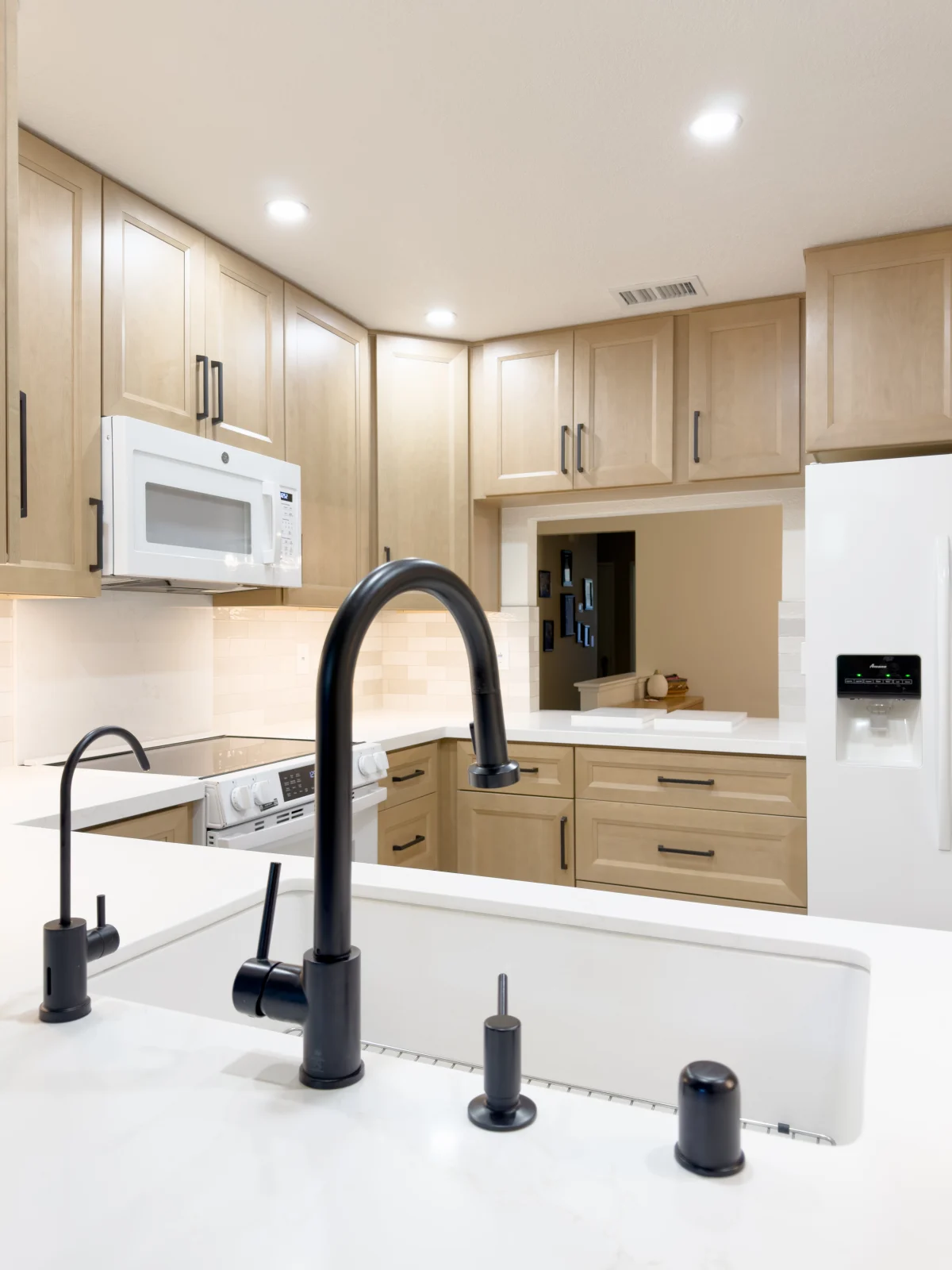 Kitchen sink with a black faucet and light wood cabinets