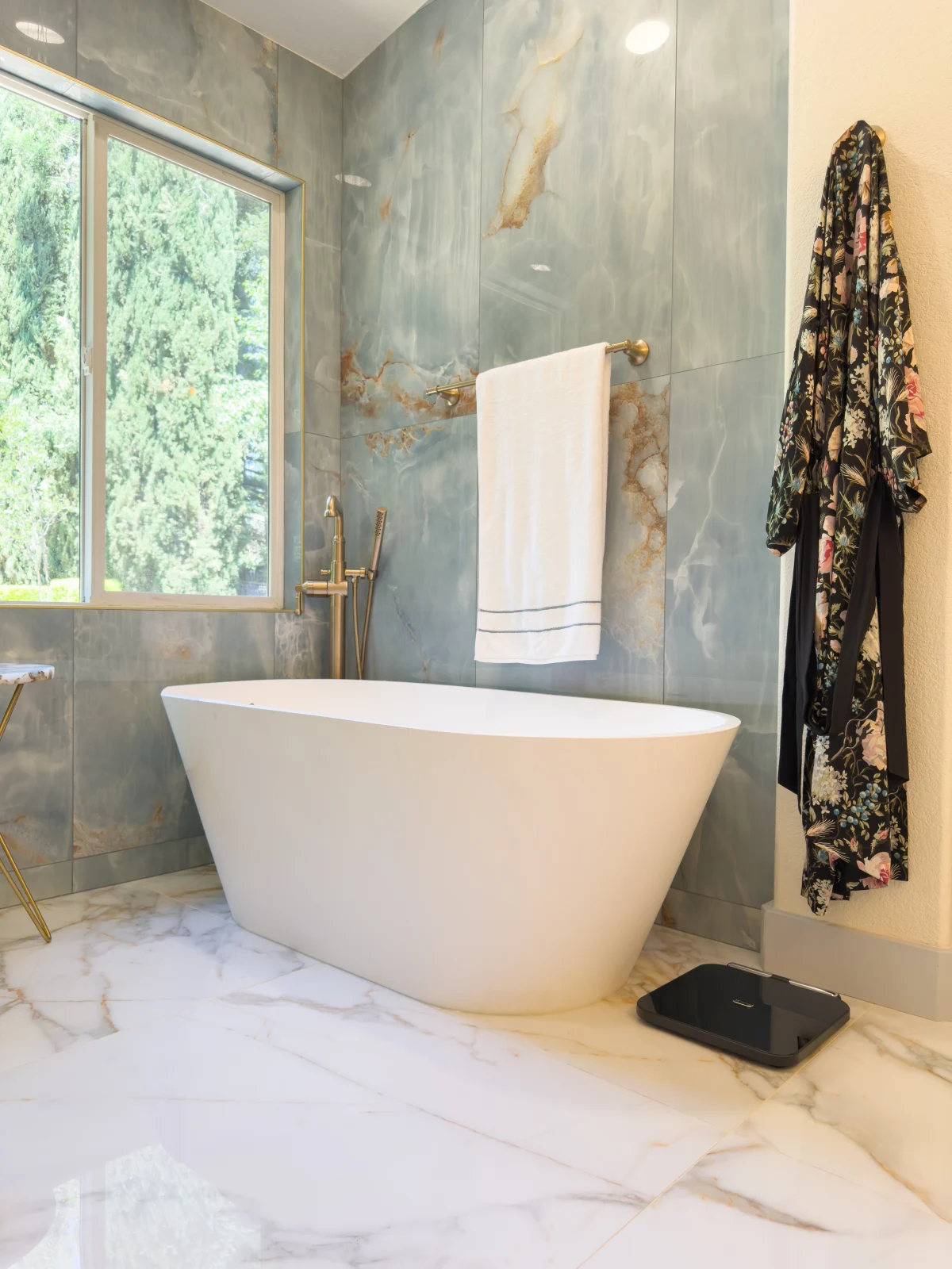 Bathroom with a freestanding tub and blue marble-look walls