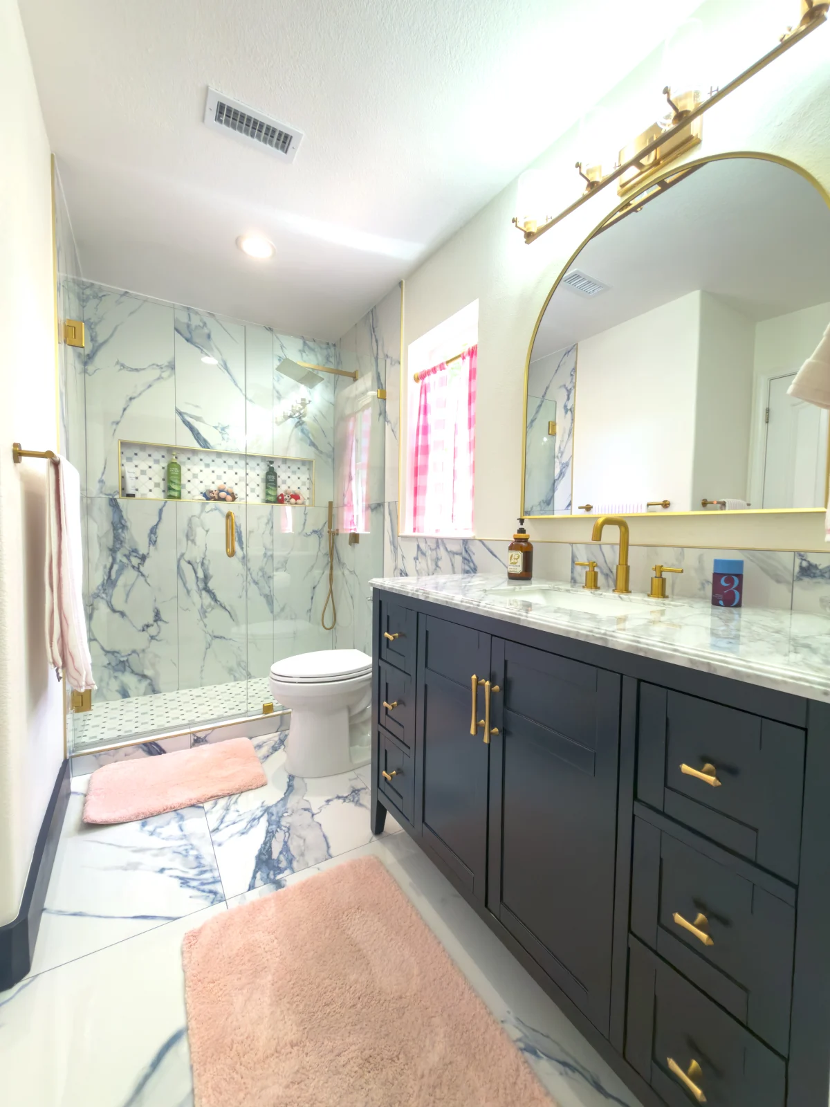 Bathroom with a navy vanity and brass fixtures