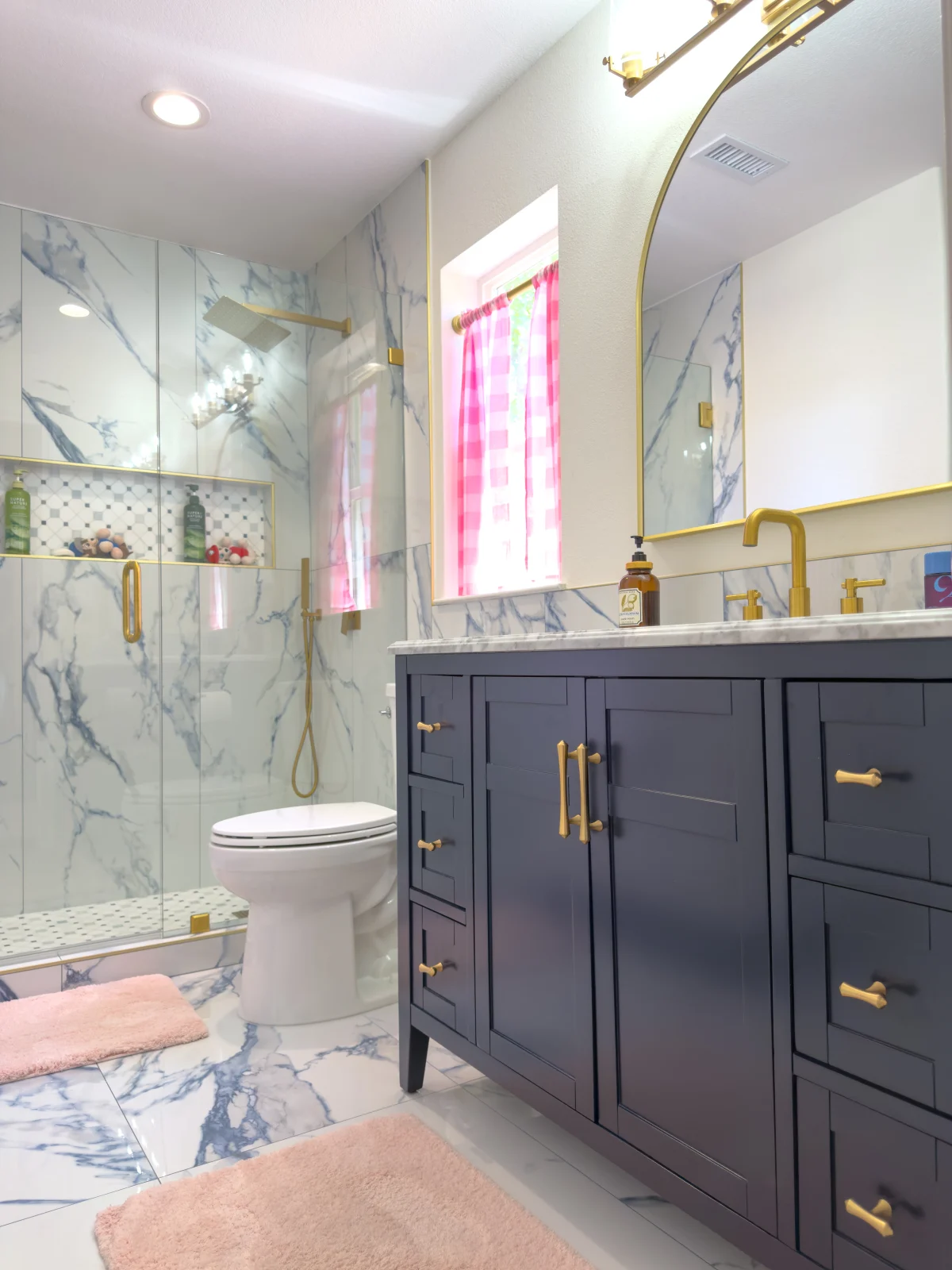 Bathroom with a navy vanity and marble-look walls