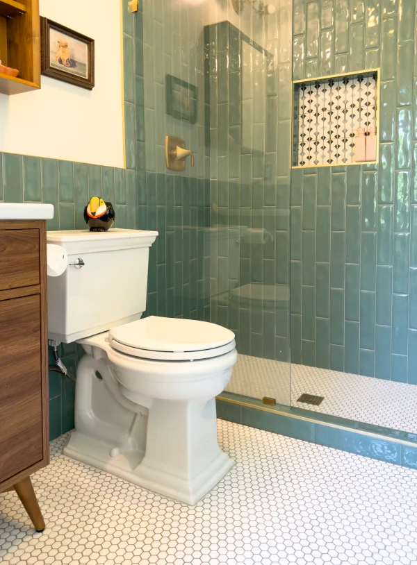 Bathroom with green tile walls and a wood vanity