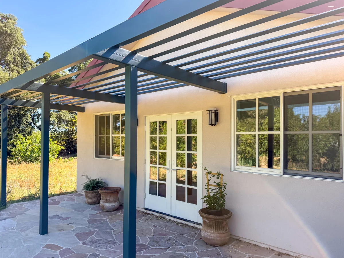 Stucco unit with French doors under a steel pergola