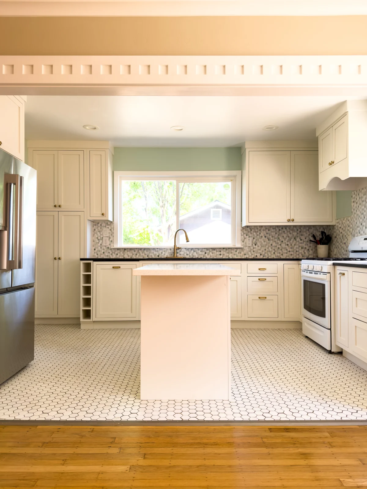 Kitchen with cream cabinets and a small island seen through a doorway