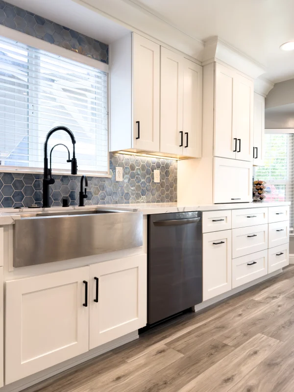 Kitchen with white shaker cabinets, a farmhouse sink and a black faucet