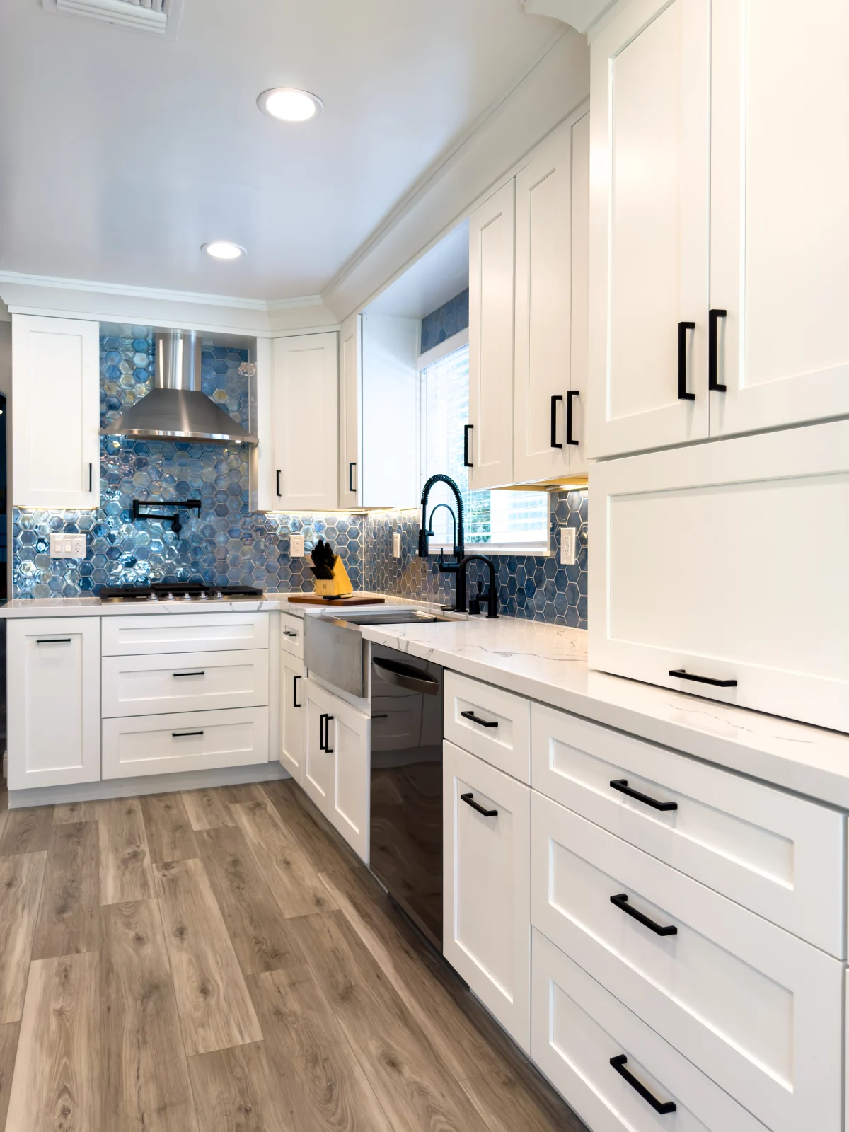 White kitchen with a mosaic backsplash and black hardware