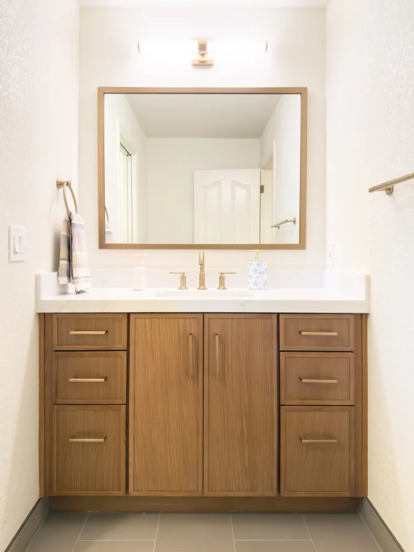 Bathroom with a wood vanity and a framed mirror