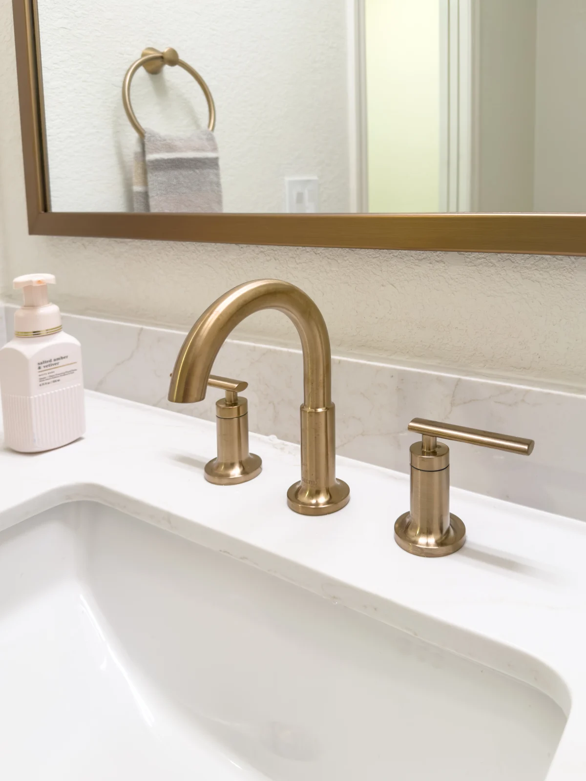 Brass faucet on a white bathroom sink