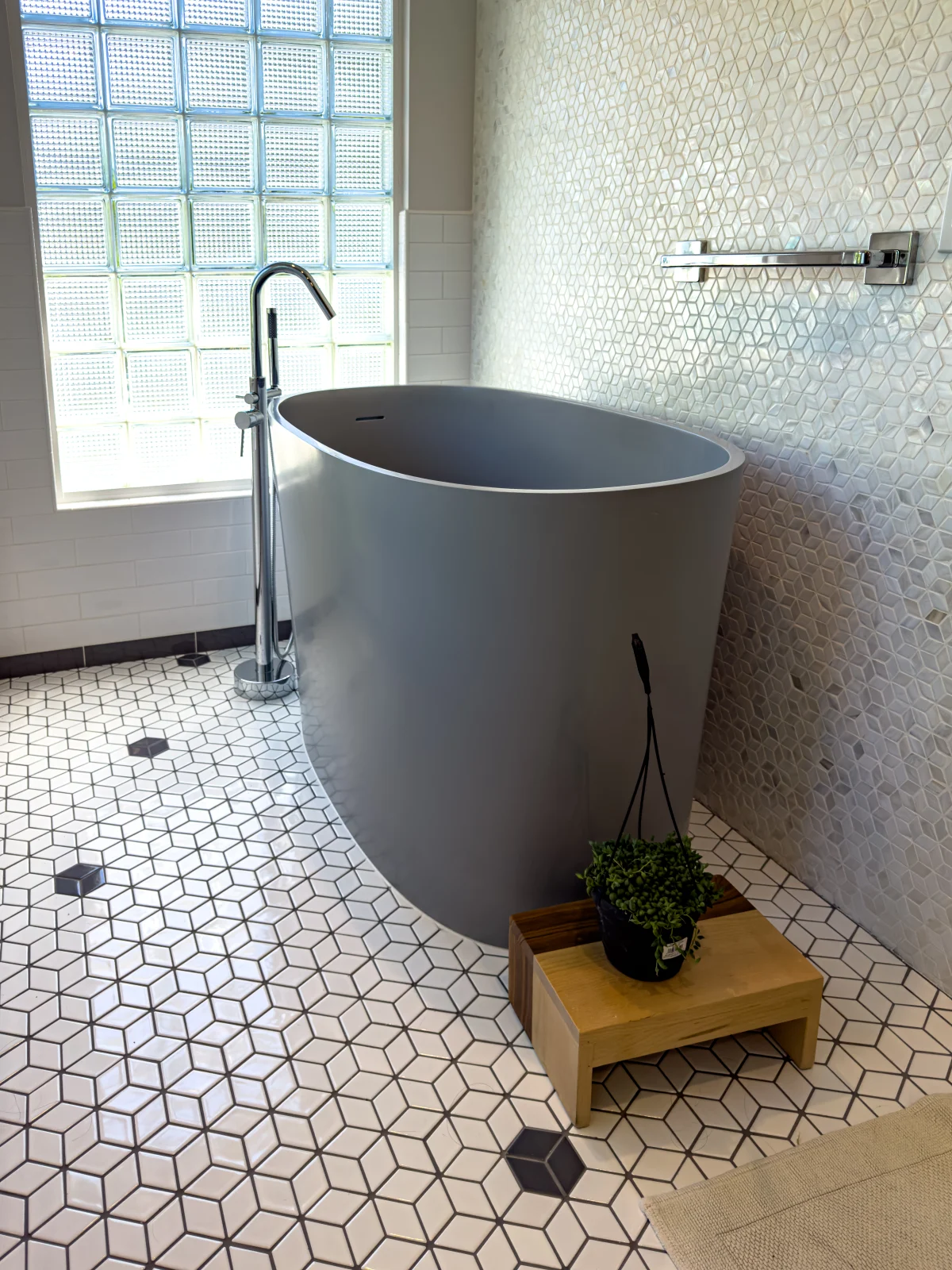 Gray freestanding tub on a geometric tile floor