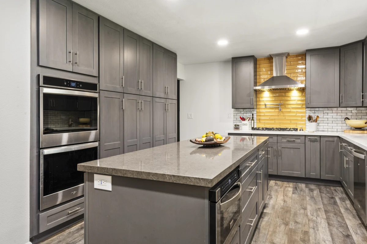 Kitchen with gray cabinets and a gold tile backsplash