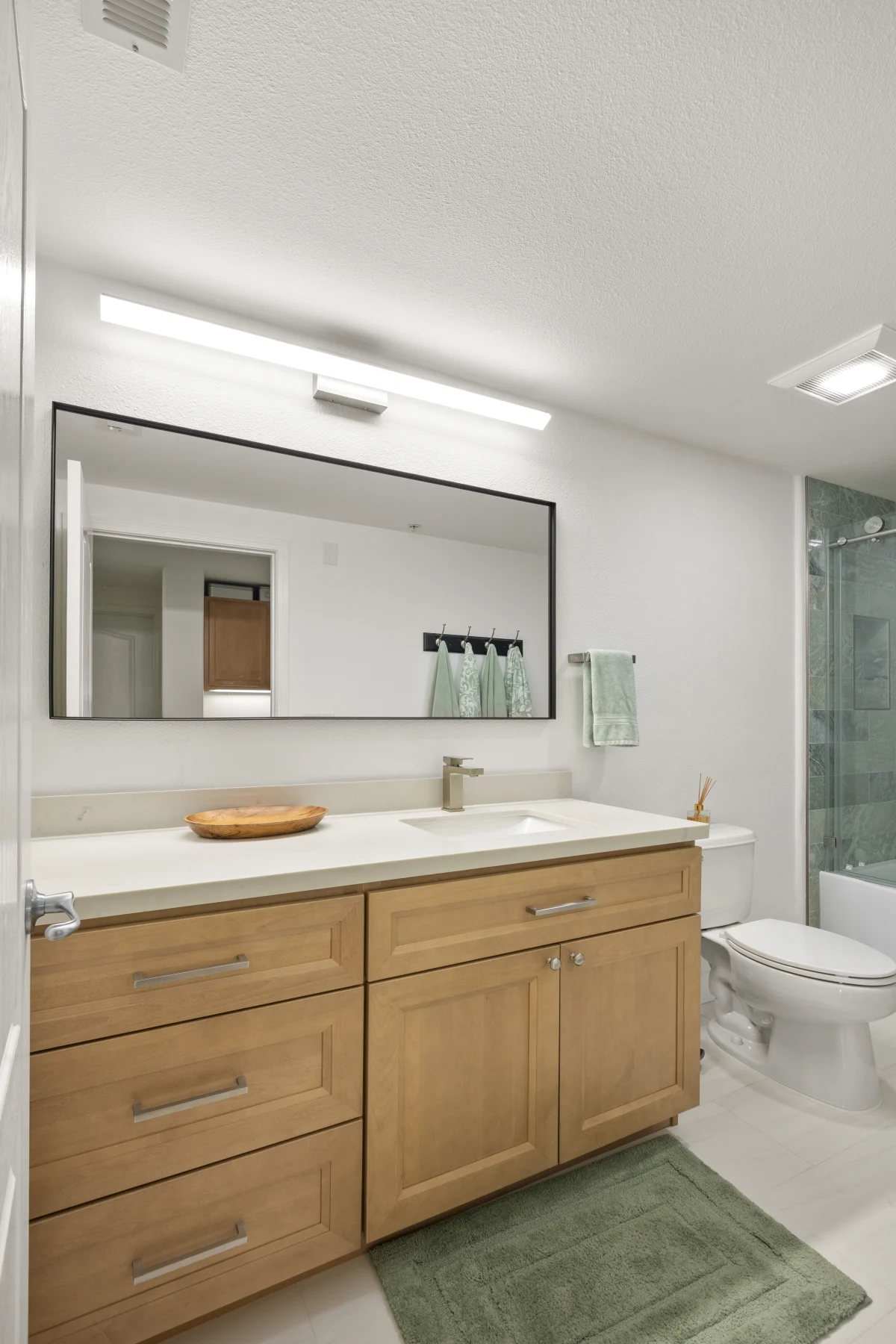 Bathroom with a wood vanity and a long mirror