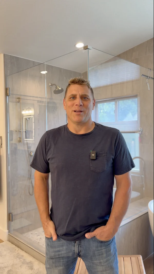 Homeowner standing in a bathroom with a glass shower