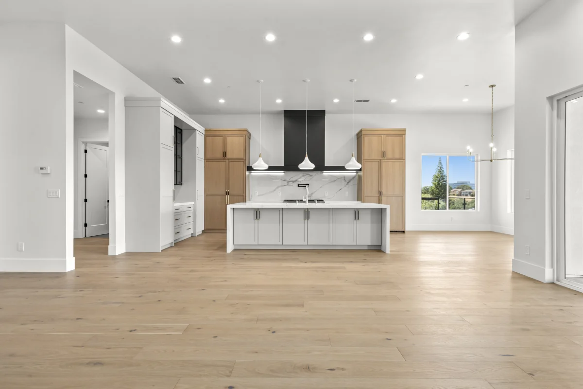 Open kitchen with a white island and light wood floors