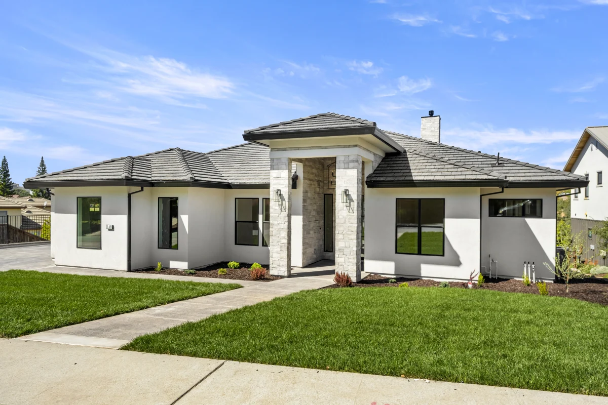 Single-storey stucco home with a stone-clad entry and a new front lawn