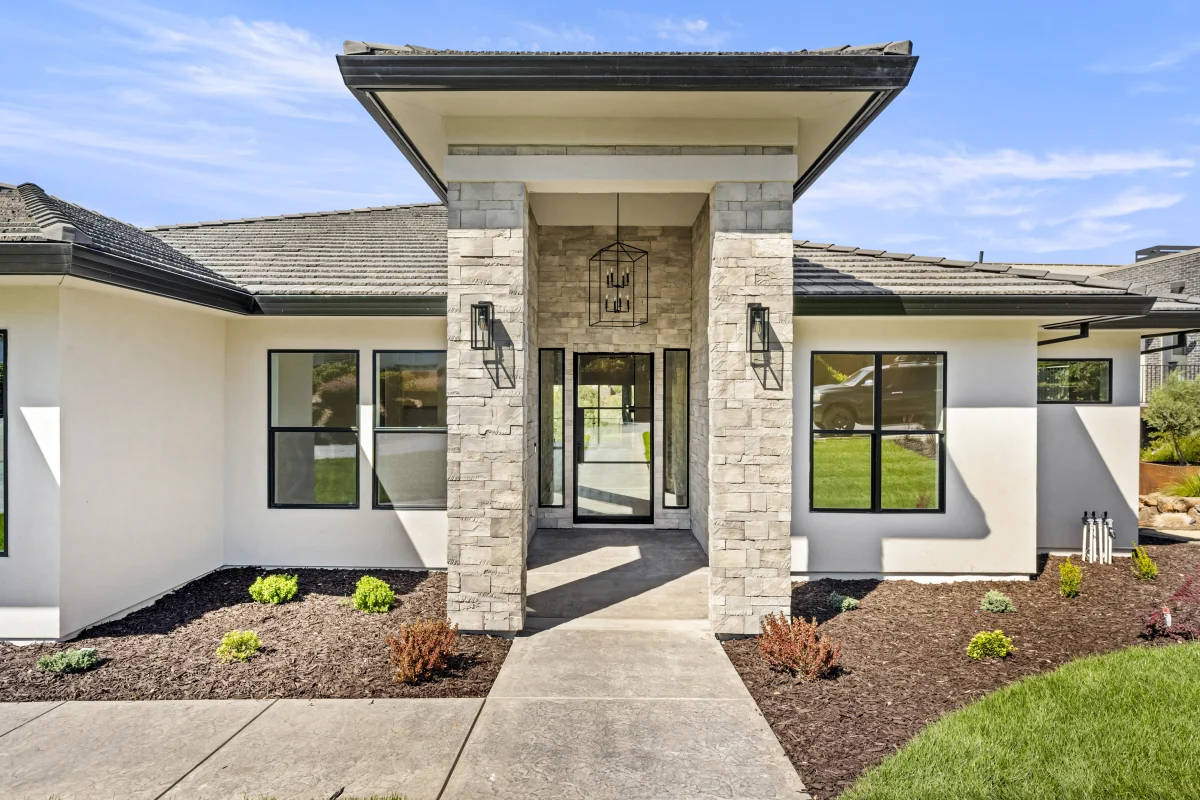 Single-story house with a stone-clad entry and dark roof