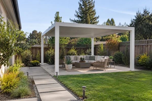 Freestanding white patio cover over seating in a backyard