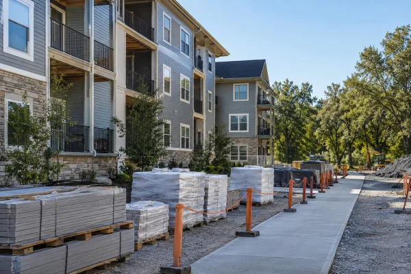 Pallets of building materials staged along an apartment walkway