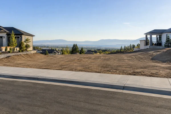Empty hillside lot beside a street with valley views